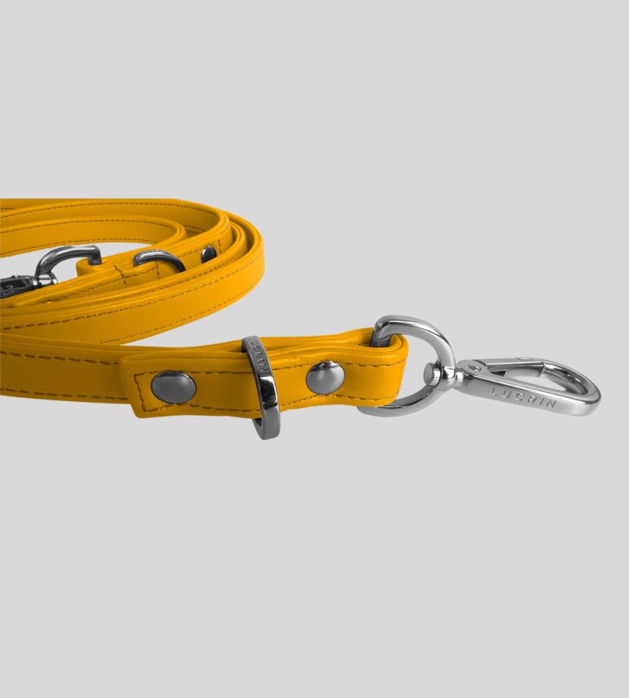 Close-up of sunny yellow leather dog leash with silver snap hook