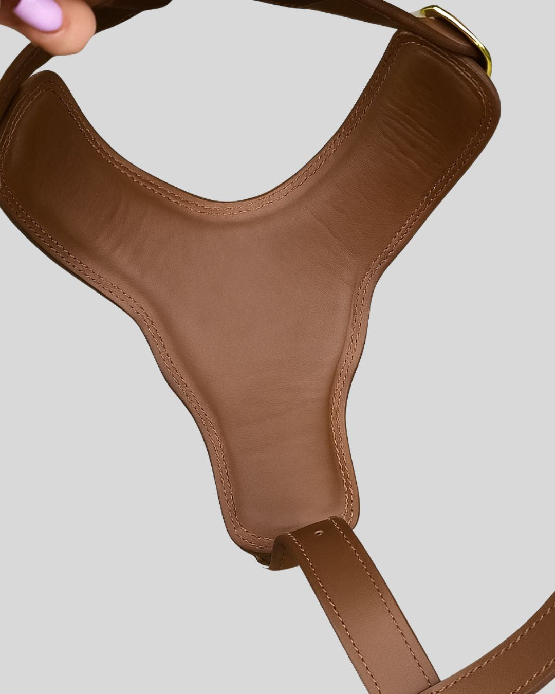 Padded underside of brown leather dog harness with interior view

