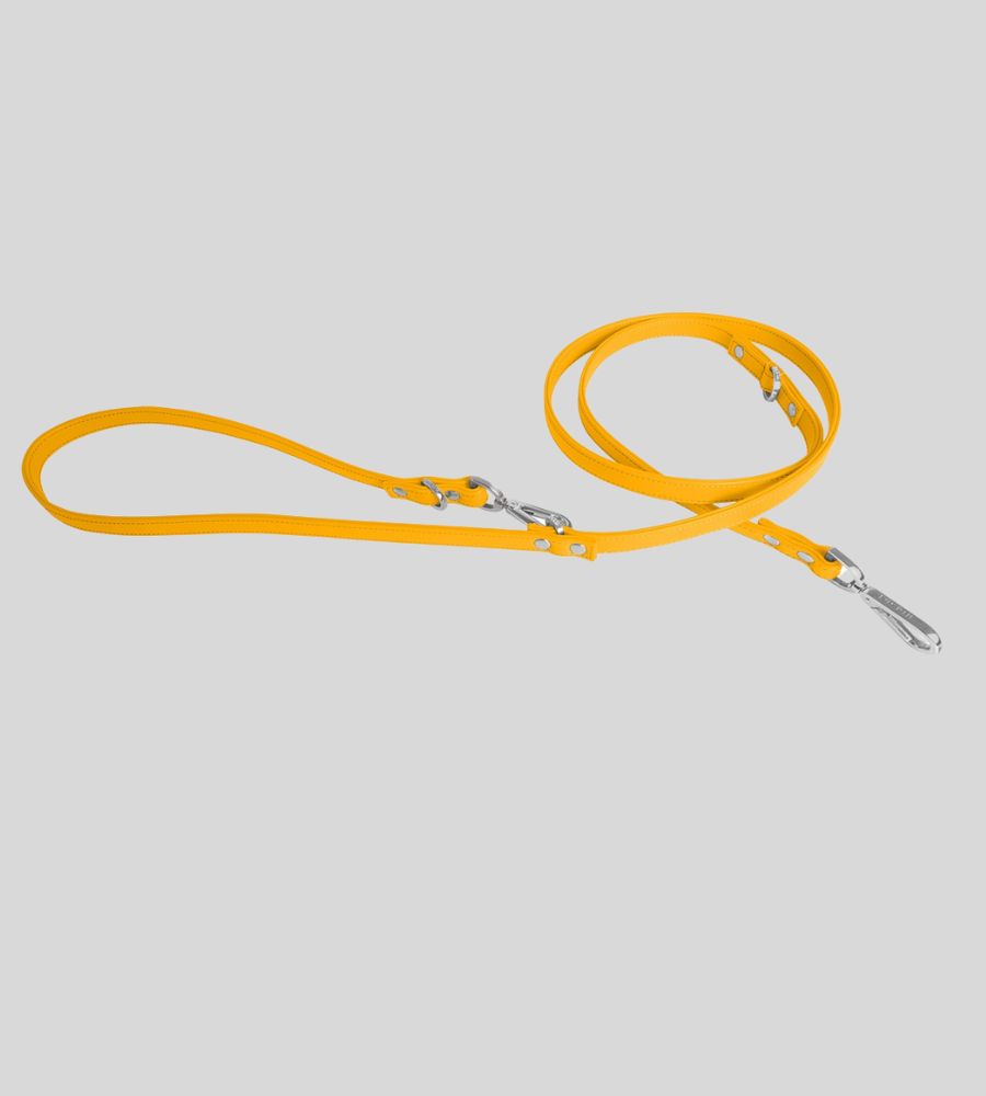 Coiled yellow leather dog leash with silver hardware and rivets